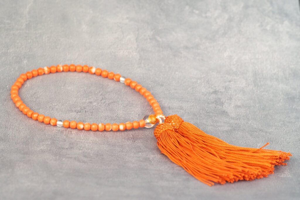 オレンジ色の珠と房の略式数珠